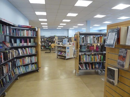Inside of public library with shelves of books on each side