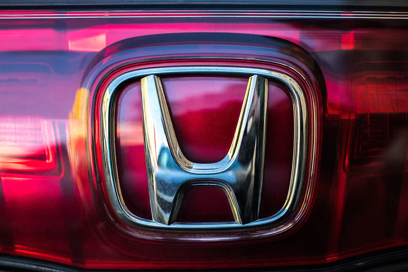Close on chrome Honda logo on red Honda vehicle