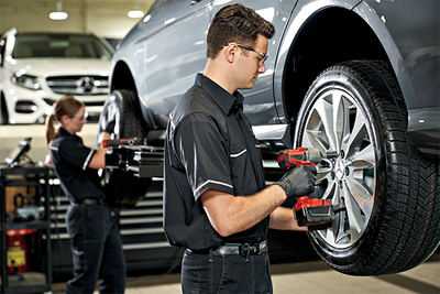Mechanic tightening lug nuts of car wheel for Honda service concept