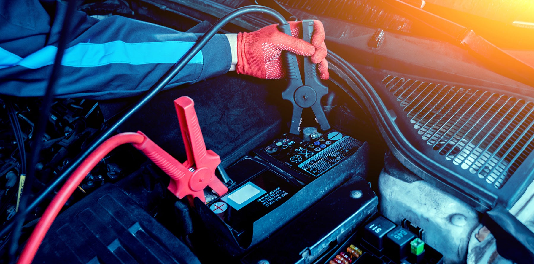 Auto technician servicing a car battery